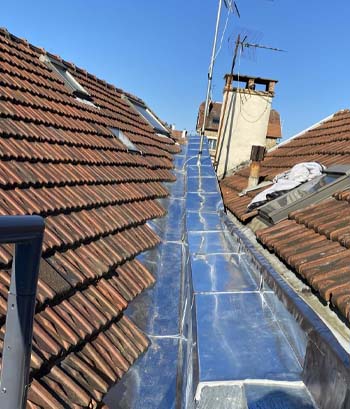 Noue en zinc réalisée entre deux pans de toiture en tuiles